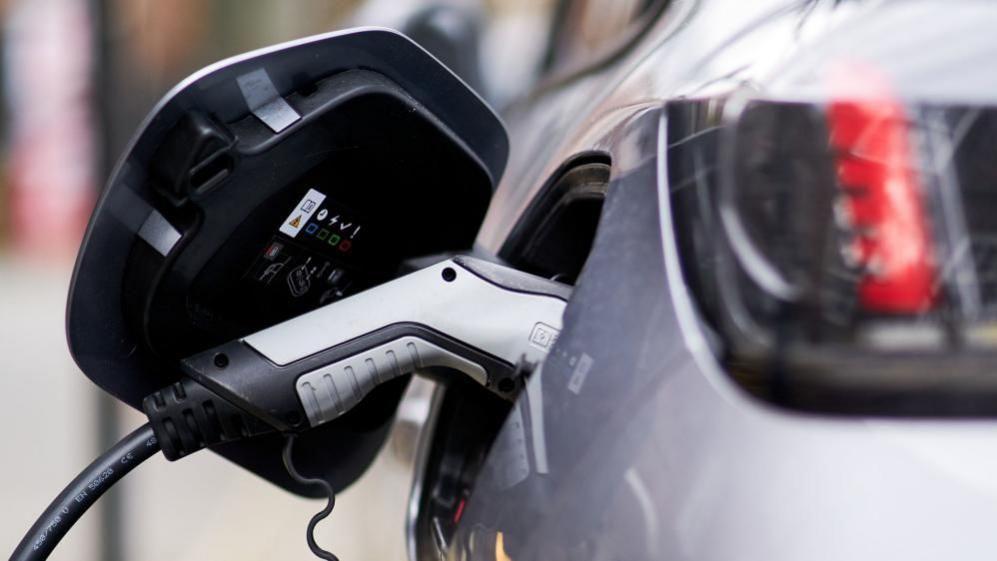 Electric vehicle plugged in for charging